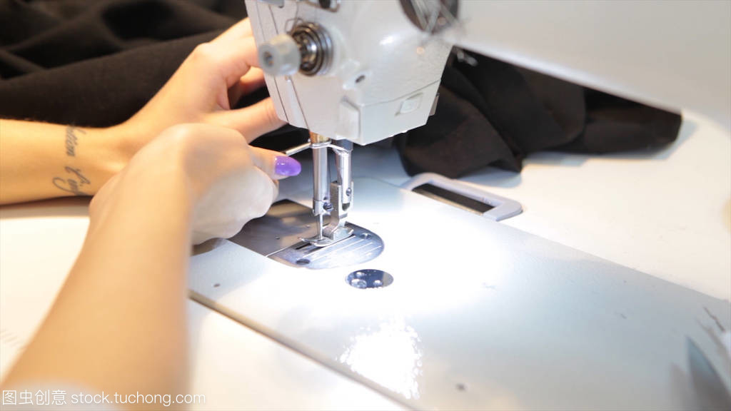 縫紉機,裁縫縫制在機器和女性的手。古董縫紉機富蘭克林。年輕女子戴防護口罩在縫紉機上工作。時尚